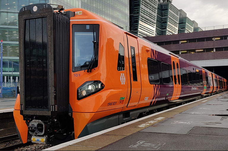 An orange train parked at a station